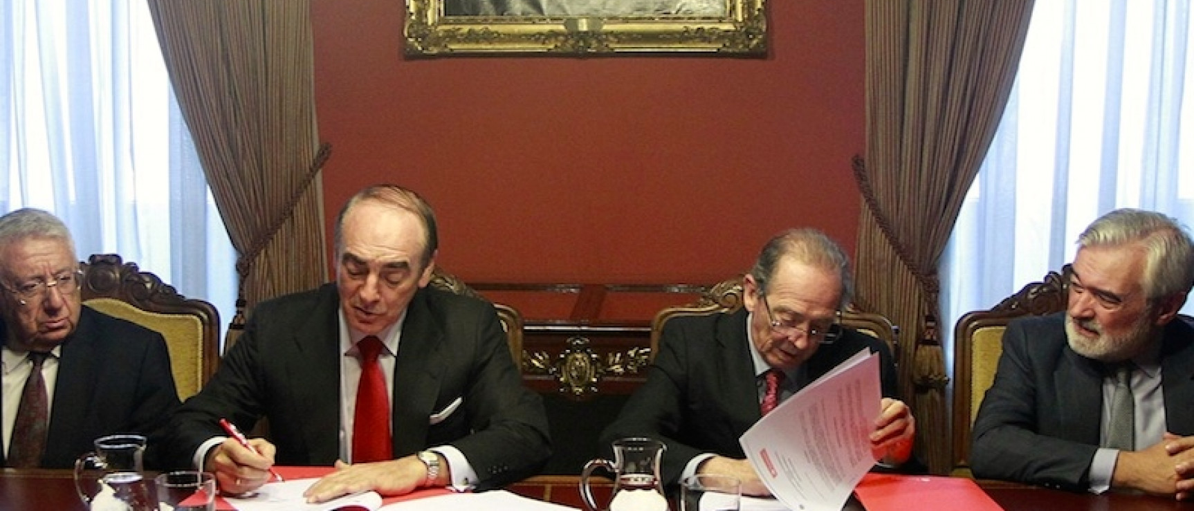 Firma del convenio entre los representantes de la RAE y de Banco Santander.