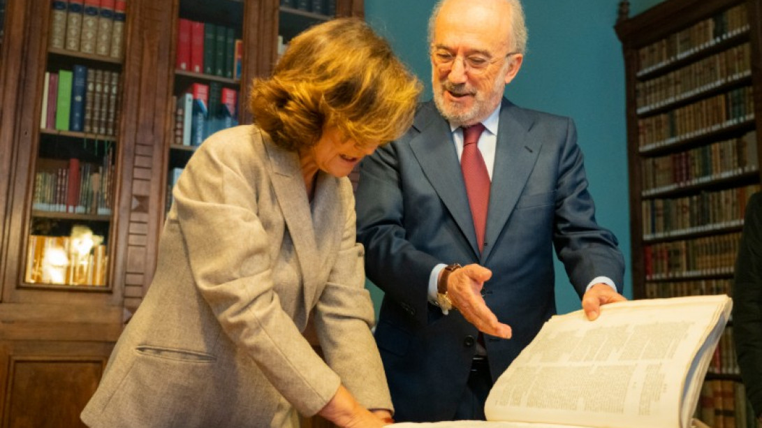 Carmen Calvo firma en el libro de honor en la biblioteca académica junto al director de la RAE (foto: RAE).